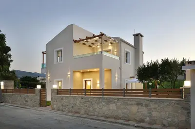 a large white house with a stone wall at Villa Despina in Kisamos in Kissamos