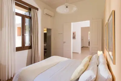a bedroom with a bed with white sheets and pillows at Villa Filoxenia 1937 in Gerani Chanion