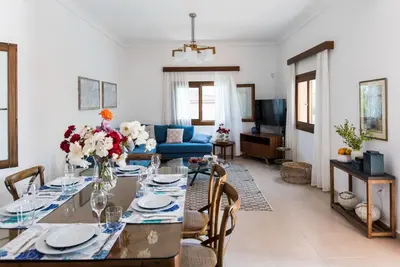 a living room with a table and a blue couch at Villa Filoxenia 1937 in Gerani Chanion