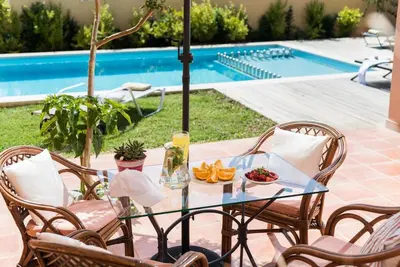 a glass table with fruit on it next to a pool at Villa Filoxenia 1937 in Gerani Chanion