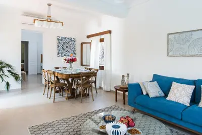 a living room with a blue couch and a table at Villa Filoxenia 1937 in Gerani Chanion
