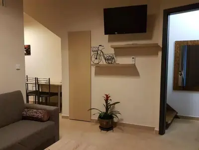 a living room with a couch and a tv on a wall at Agora Apartments Ground Floor in Kissamos