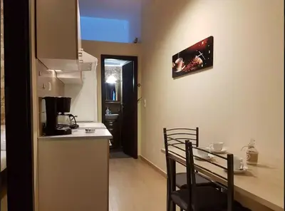 a small kitchen with a counter and a table and chairs at Agora Apartments Ground Floor in Kissamos