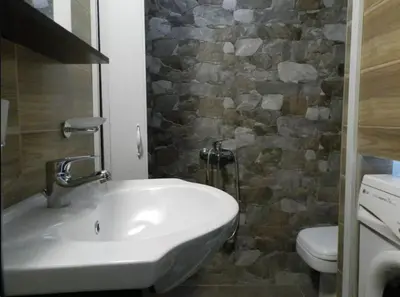 a bathroom with a sink and a stone wall at Agora Apartment First Floor in Kissamos