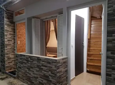 a room with a brick wall with a mirror at Agora Apartment First Floor in Kissamos