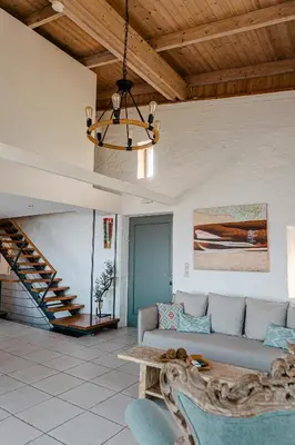 a living room with a couch and a chandelier at Yellow Dream Villas in Chorafakia