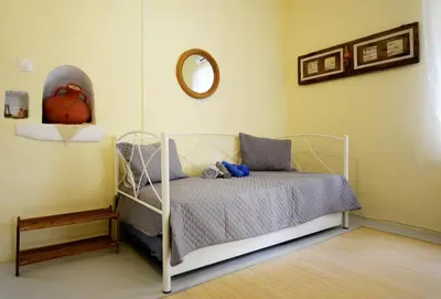 a bedroom with a bed and a mirror on the wall at Traditional Cretan Country House (9klm from Elafonissi) in Plokamianá