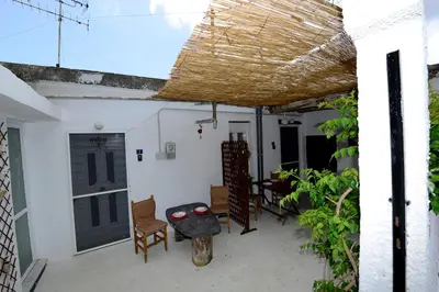 a room with a porch with a door and chairs at Traditional Cretan Country House (9klm from Elafonissi) in Plokamianá