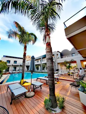 a deck with two palm trees and a swimming pool at Libyan Princess in Palaiochóra