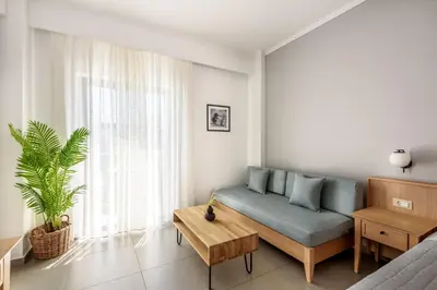 a living room with a blue couch and a table at Libyan Princess in Palaiochóra