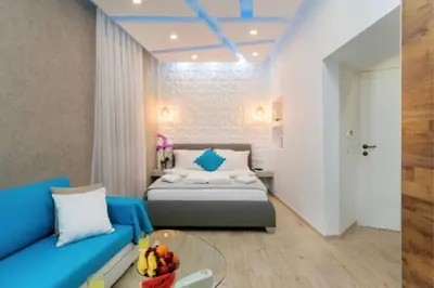 a bedroom with a bed and a blue couch at Diamond Luxury Suites in Chania Town