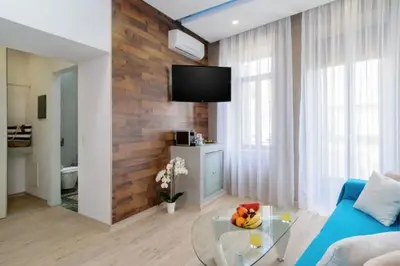 a living room with a blue couch and a glass table at Diamond Luxury Suites in Chania Town