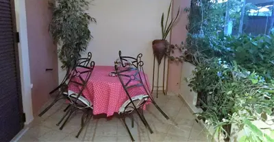 a table and chairs with a pink table and plants at Rosmarino in Kissamos