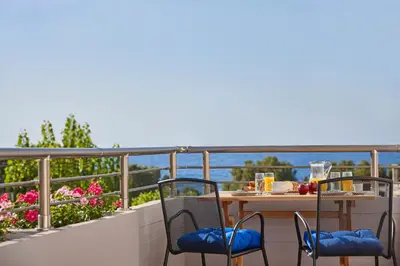 a table and chairs on a balcony with a view of the water at La Vita Classica in Chania Town