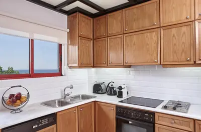 a kitchen with wooden cabinets and a sink at La Vita Classica in Chania Town