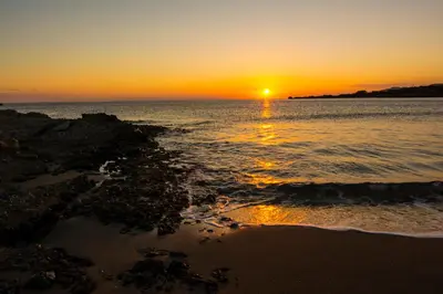 a sunset over the ocean with the sun setting at Villas Paleochora in Palaiochóra