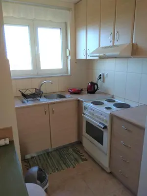 a kitchen with a stove and a sink and two windows at Studios Staring at the Sunset in Chania Town