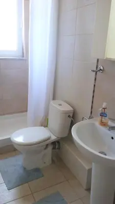 a white bathroom with a toilet and a sink at Studios Staring at the Sunset in Chania Town