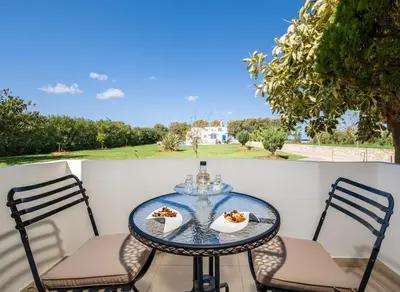 a table and chairs with food on a balcony at Oasea in Tavronitis