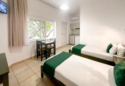 a hotel room with two beds and a table at Akti Galinis in Kalyves