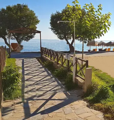 a wooden fence next to a beach with the ocean at Akti Galinis in Kalyves