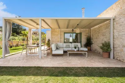 a patio with a couch and a table at Kontis Village in Fílippos