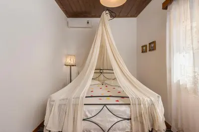 a bedroom with a bed with a mosquito net at Villa Drakona in Keramia