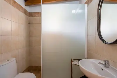 a bathroom with a white toilet and a sink at Villa Drakona in Keramia