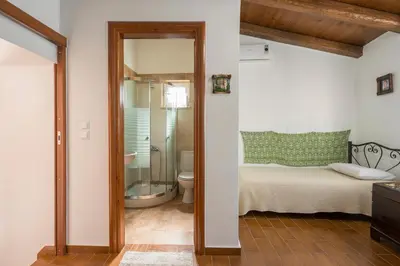 a bathroom with a shower and a toilet and a bed at Villa Drakona in Keramia
