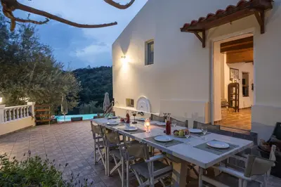 a patio with a table and chairs and a house at Villa Drakona in Keramia