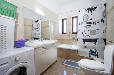 a bathroom with a washer and dryer in it at Seaside Villa Balos in Kissamos