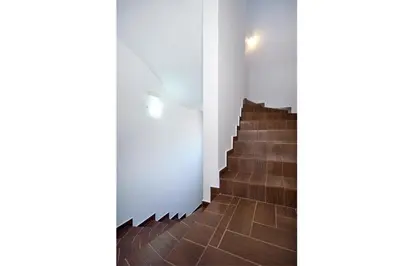 a staircase with wooden floors and a white wall at Seaside Villa Balos in Kissamos