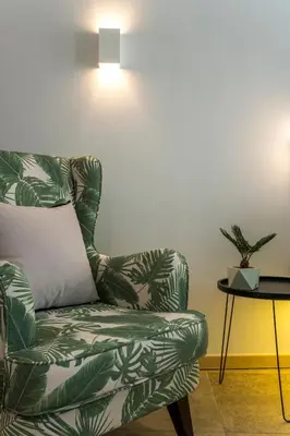 a living room with a chair and a lamp at Kalamaki Luxury Suites in Kalamaki Chanion