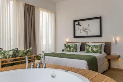 a hotel room with a bed and a bath tub at Kalamaki Luxury Suites in Kalamaki Chanion