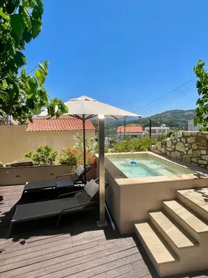 a patio with an umbrella and a swimming pool at Kamares Sanctuaries in Kolymvari