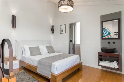 a white bedroom with a bed and a mirror at Kamares Sanctuaries in Kolymvari