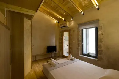 a bedroom with a large white bed and a window at Evans House II in Chania Town