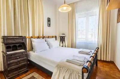 a bedroom with a bed with a dresser and a window at Central luxurious Apartment with sea view! in Chania Town