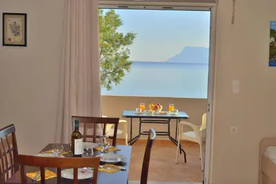 a dining room with a table and a view of the ocean at Beach House in Kissamos