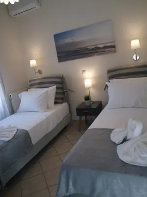 a hotel room with two beds with white pillows at Urban Sea Apts in Chania Town