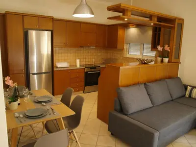 a living room with a couch and a table in a kitchen at Urban Sea Apts in Chania Town