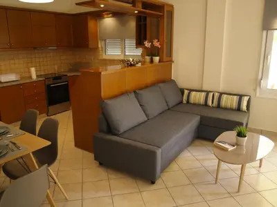 a living room with a couch and a kitchen at Urban Sea Apts in Chania Town