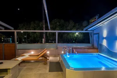 a swimming pool at night with a table and a bench at UTOPIA luxury apartment in Chania Town