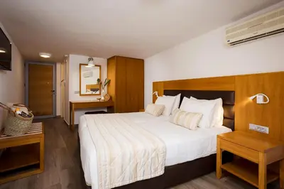 a hotel room with a large bed and a table at Stellina Village in Kato Daratso