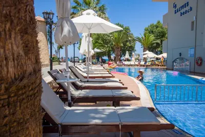 a row of lounge chairs next to a swimming pool at Kalyves Beach Hotel in Kalyves