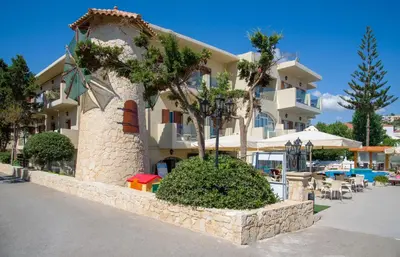 a large building with a tree in front of it at Kalyves Beach Hotel in Kalyves