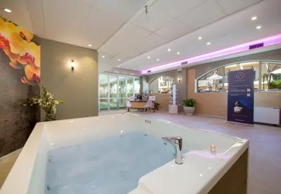 a large bath tub with a sink in a room at Kalyves Beach Hotel in Kalyves