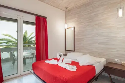 a bedroom with a red bed with towels on it at Sevach Apartments in Kalamaki Chanion