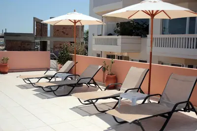 a row of chairs and umbrellas on a roof at Sevach Apartments in Kalamaki Chanion