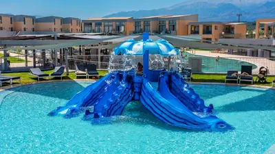 a blue water slide in a swimming pool at Kiani Beach Resort Family All Inclusive in Kalyves